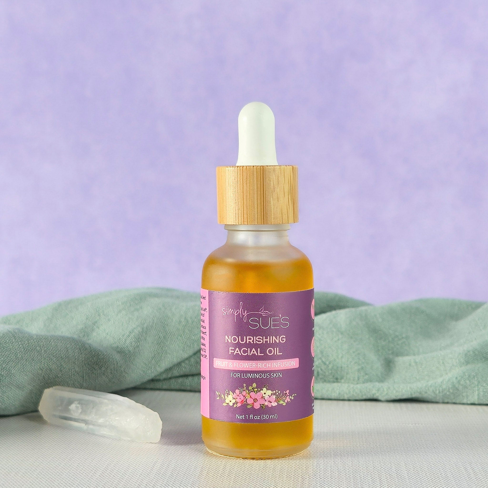 Natural facial oil in glass dropper bottle with bamboo cap on soft purple background