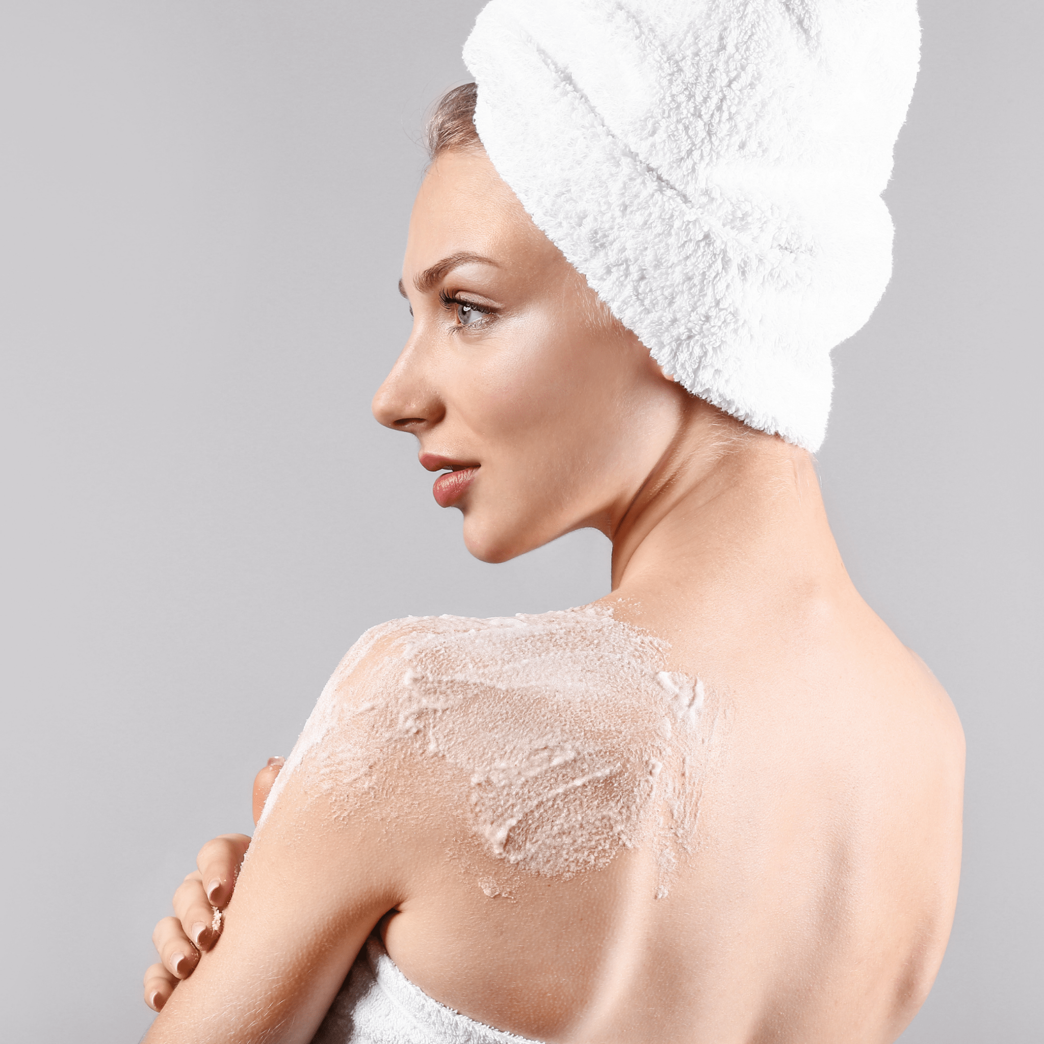 A mature woman showing the lavender body polish on the back of her shoulder