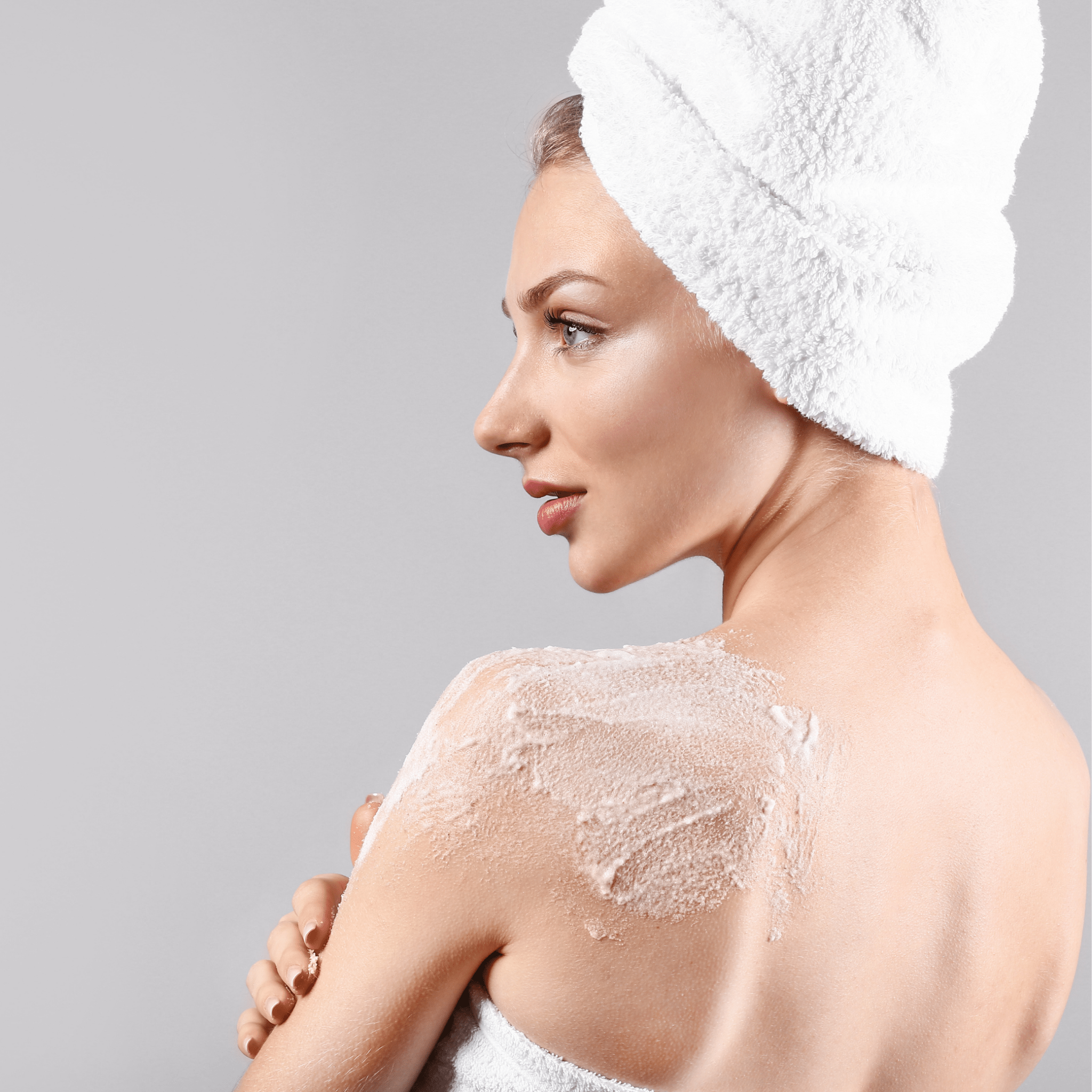 A mature woman applying the body polish to the back of her should to show the texture