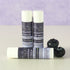 Wild blueberry lip balm tubes by Simply Sue’s with blueberries on a neutral background
