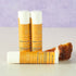 Lemon pound cake lip balm tubes by Simply Sue’s with lemon slices on a neutral background