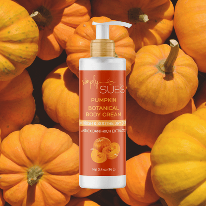 Simply Sue’s Pumpkin Body Cream with a background of fresh orange pumpkins